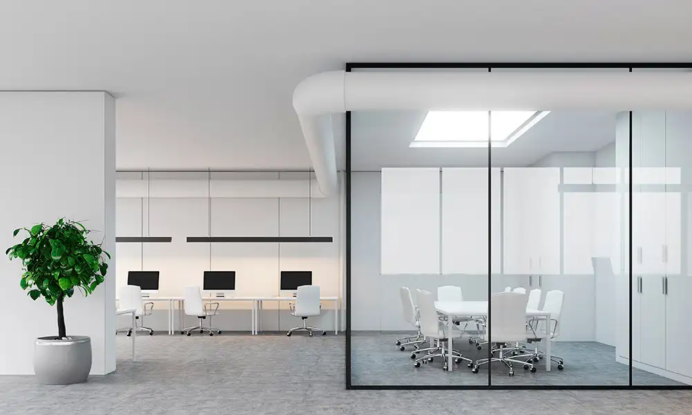 Oficina moderna y luminosa dividida con mamparas de vidrio de suelo a techo.